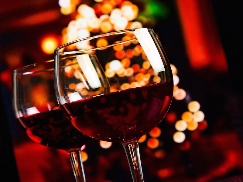 Two Red Wine Glass Against Christmas Lights Decoration Background